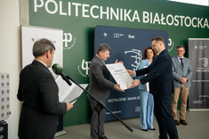 Minister P. Czarnek wręcza czek rektorowi prof. P. Koszelnikowi,